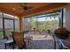 Outdoor screened lanai featuring stone flooring, ceiling fan, seating, and grill at 5020 Savona Run, Bradenton, FL 34211