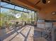 Outdoor screened lanai featuring stone flooring, ceiling fan, seating, and grill at 5020 Savona Run, Bradenton, FL 34211
