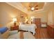 Inviting main bedroom with warm colors, a ceiling fan, and a relaxing sitting area at 5020 Savona Run, Bradenton, FL 34211