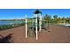 A vibrant playground with a play structure, set against a backdrop of a tranquil lake and well-maintained landscaping at 5020 Savona Run, Bradenton, FL 34211
