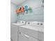 Laundry room includes a washing machine and dryer with shelving for storage at 5132 Rocky Coast Pl, Palmetto, FL 34221