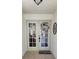 Welcoming foyer with double glass doors adorned with a decorative wreath and a neutral tiled floor at 625 Duchess Blvd, Dunedin, FL 34698