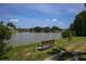 Picturesque lake view featuring benches along the grassy shore, inviting residents to relax and appreciate the serene setting at 1536 47Th Avenue E Dr, Ellenton, FL 34222