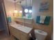 Bathroom with a single vanity, globe lighting, and a decorative 