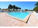 Large community pool with brick paver deck and mature landscaping on a bright, sunny day at 1750 Palm Springs St, Sarasota, FL 34234