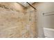 Bathroom featuring glass enclosed shower, natural stone accents, and a pebble tile shower floor at 1930 Harbourside Dr # 117, Longboat Key, FL 34228