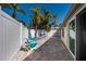 A spacious back patio, with dining and lounge seating, offers peaceful outdoor living amid tropical landscaping at 231 Hourglass Way # V5, Sarasota, FL 34242