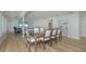 Bright dining room featuring wood floors and large dining table with living room in the background at 231 Hourglass Way # V5, Sarasota, FL 34242