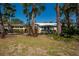 Charming single-story home featuring a well-maintained lawn and lush, tropical landscaping with beautiful palm trees at 231 Hourglass Way # V5, Sarasota, FL 34242