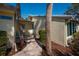 Inviting front porch featuring lovely blue chairs, a charming walkway and tropical trees at 231 Hourglass Way # V5, Sarasota, FL 34242