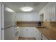 Efficient kitchen featuring ample white cabinetry, essential appliances, and a clean, functional design at 231 Hourglass Way # V5, Sarasota, FL 34242
