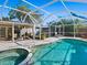 Backyard pool and spa area with a screened enclosure and access to outdoor dining at 2376 Novus St, Sarasota, FL 34237
