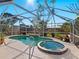 Relax in the screened-in pool area with a hot tub surrounded by lush landscaping at 2376 Novus St, Sarasota, FL 34237