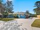 Beautiful blue single-story home with a well-maintained lawn, mature trees, and a spacious driveway at 2376 Novus St, Sarasota, FL 34237