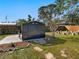 Backyard featuring a storage shed, grassy area, and decorative landscaping at 2376 Novus St, Sarasota, FL 34237