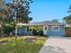 Inviting one-story home featuring a well-kept lawn, mature trees, and a concrete driveway at 2376 Novus St, Sarasota, FL 34237