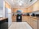 Cozy kitchen with modern appliances, light wood cabinetry, and white tile floors at 2376 Novus St, Sarasota, FL 34237