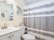 Clean bathroom with a vanity, toilet, and a shower with striped curtain at 2376 Novus St, Sarasota, FL 34237