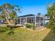 Spacious backyard featuring a screened-in pool area, lush greenery, and a storage shed at 2376 Novus St, Sarasota, FL 34237