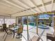 Enjoy outdoor dining on the screened patio with a ceiling fan overlooking the pool and hot tub at 2376 Novus St, Sarasota, FL 34237