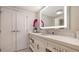 Well-lit bathroom featuring marble counters, cabinets, and double doors at 250 Sands Point Rd # 5101, Longboat Key, FL 34228