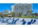 Beautiful beach with multiple chairs and building view for a relaxing day by the ocean at 250 Sands Point Rd # 5101, Longboat Key, FL 34228
