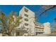 Modern condo building with manicured landscaping, garage parking, and beach access at 250 Sands Point Rd # 5101, Longboat Key, FL 34228