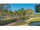 Lush landscaping with palm trees along walking path by community lake at 250 Sands Point Rd # 5101, Longboat Key, FL 34228
