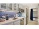 Kitchen with stainless steel appliances, counter space and blue backsplash at 250 Sands Point Rd # 5101, Longboat Key, FL 34228