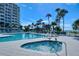 Resort-style pool and hot tub area with palm trees and blue skies in the background at 250 Sands Point Rd # 5101, Longboat Key, FL 34228