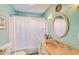 Aqua bathroom featuring an oval mirror, neutral vanity and a shower with white curtain at 2812 Casey Key Rd, Nokomis, FL 34275