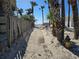 Sandy beach path between palm trees and a weathered fence, leading toward the beautiful ocean at 2812 Casey Key Rd, Nokomis, FL 34275