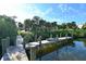 Wooden dock overlooking tranquil water, surrounded by lush, tropical landscaping at 2812 Casey Key Rd, Nokomis, FL 34275