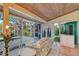 Cozy sitting area with floral sofa and view of the screen enclosed pool at 2812 Casey Key Rd, Nokomis, FL 34275