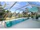 Long, screened-in pool with clear blue water and palm tree views at 2812 Casey Key Rd, Nokomis, FL 34275