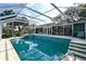 Screened in pool with stairs, spa and surrounding yard at 2812 Casey Key Rd, Nokomis, FL 34275