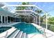Screened in pool and spa with white lounge furniture and stairs at 2812 Casey Key Rd, Nokomis, FL 34275