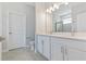 Bright bathroom featuring double sinks, white cabinetry and a large mirror at 3294 Gowanda Ave, North Port, FL 34287