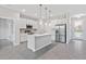 Modern kitchen featuring white cabinets, stainless steel appliances, an island, and bright lighting at 3294 Gowanda Ave, North Port, FL 34287