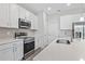 Modern kitchen with stainless steel appliances, white cabinetry, and a beautiful tile backsplash at 3294 Gowanda Ave, North Port, FL 34287
