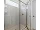 Bathroom shower featuring glass doors, tiled walls, and modern fixtures at 3294 Gowanda Ave, North Port, FL 34287