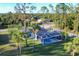 Aerial view of a home with a screened pool, surrounded by trees and a lush lawn at 4529 Crowell Ln, North Port, FL 34288
