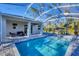 Sparkling pool with a screened enclosure, a shaded seating area, and a clear blue sky above at 4529 Crowell Ln, North Port, FL 34288
