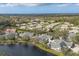 Expansive aerial view highlighting a community with mature trees, lake, and well-maintained residences at 4563 Whirlaway Dr # C, Sarasota, FL 34233