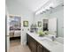 Bright bathroom featuring a double sink vanity with modern fixtures and a view into the bedroom at 4563 Whirlaway Dr # C, Sarasota, FL 34233