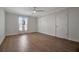 Spacious bedroom with wood-look flooring, ceiling fan, and natural light at 5115 Island Date Way, Sarasota, FL 34232