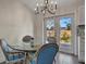 Cozy dining area with a round glass table, French doors, and a view of the backyard and updated kitchen at 5115 Island Date Way, Sarasota, FL 34232