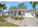 Inviting single-story home with a well-kept lawn and a paved driveway leading to an attached garage at 5115 Island Date Way, Sarasota, FL 34232