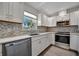 Updated kitchen boasts stainless steel appliances, mosaic backsplash, and bright white cabinets at 5115 Island Date Way, Sarasota, FL 34232
