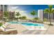 An outdoor swimming pool with lounge chairs and tropical landscaping at 555 Quay Cmn # 401, Sarasota, FL 34236